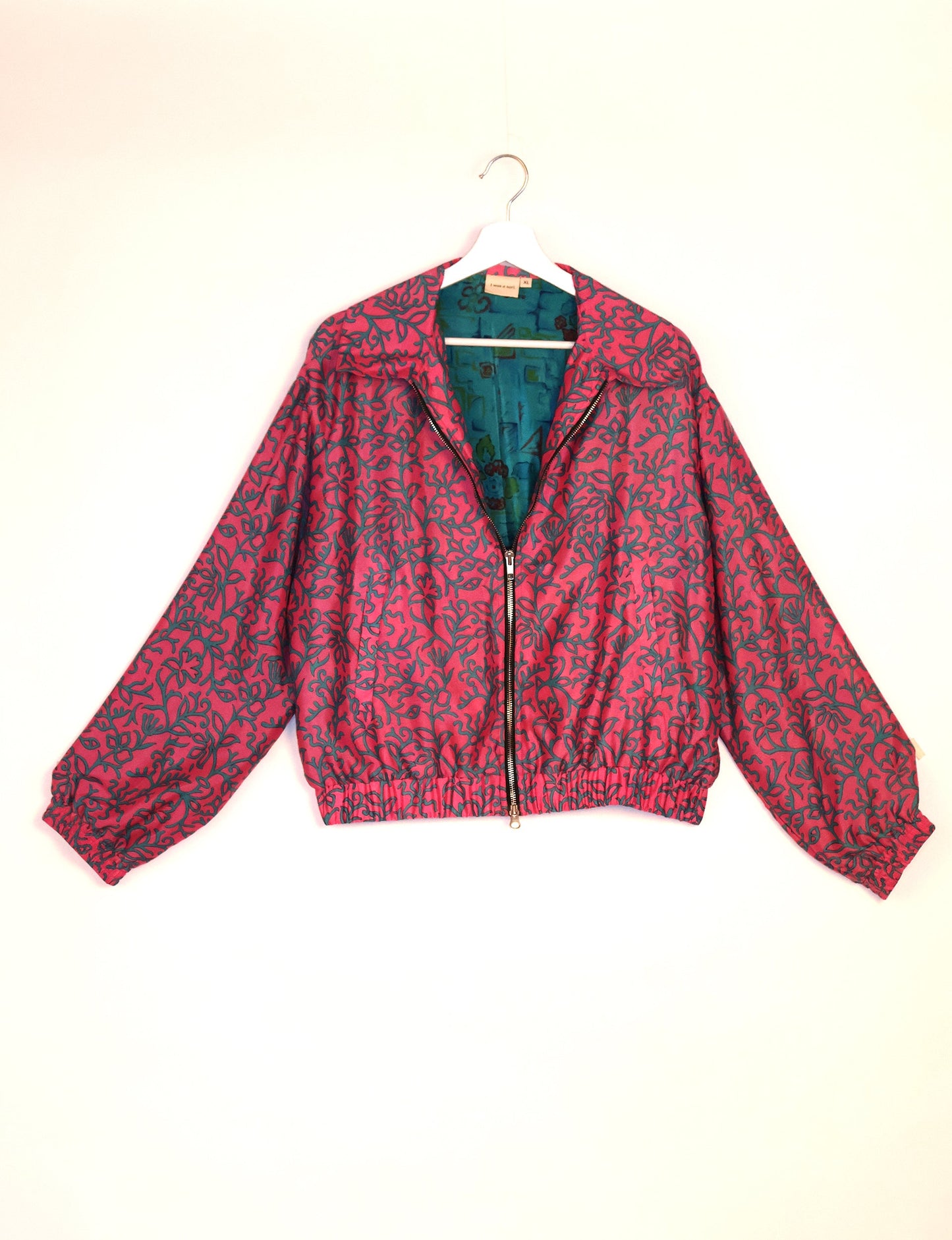 Stylish BOMBER JACKET, an upcycled clothing masterpiece with a cute cropped shape, elasticated details, and detachable metallic zipper. Contrast sari print lining adds a unique touch. Explore sustainable and eco-friendly fashion.