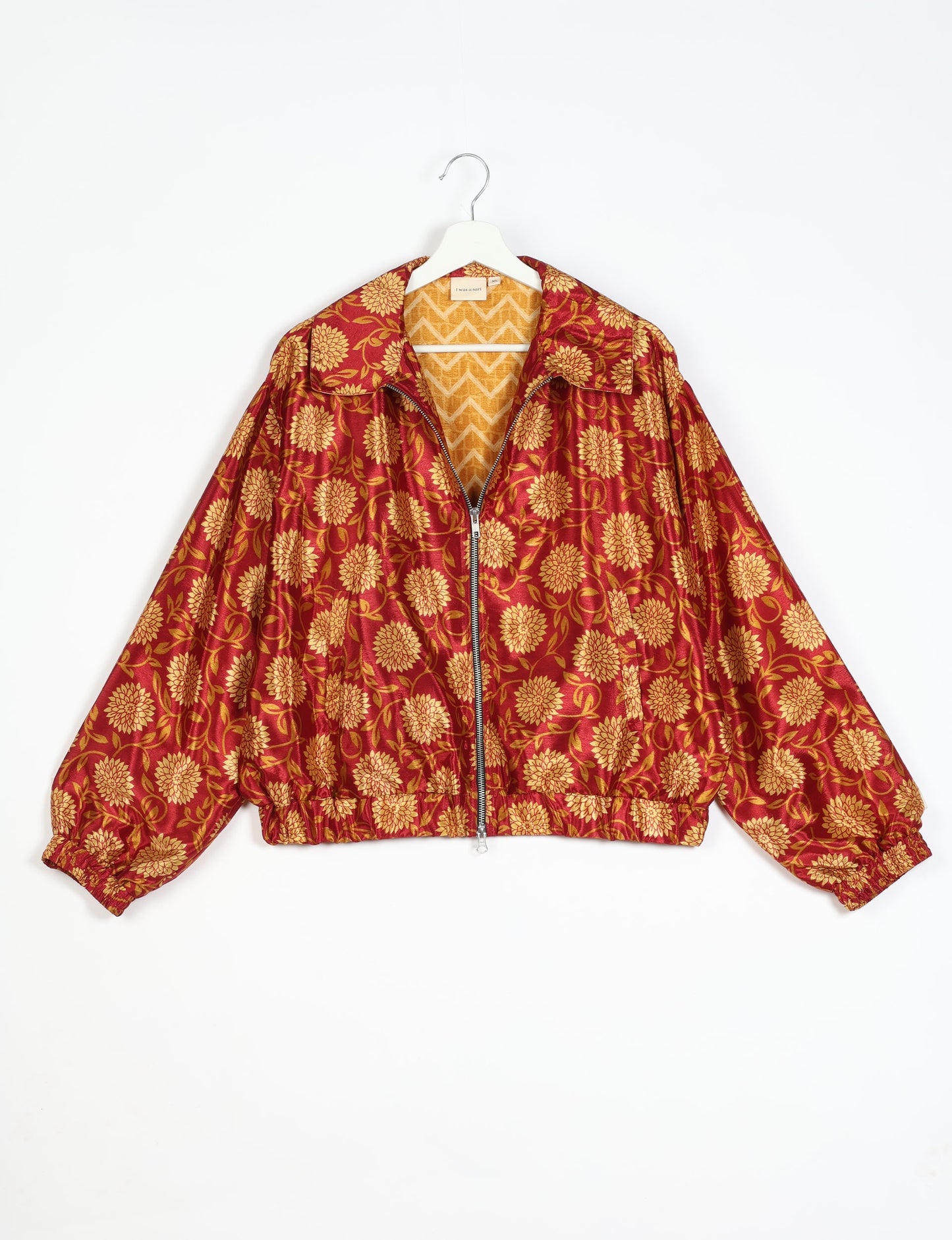 Stylish BOMBER JACKET, an upcycled clothing masterpiece with a cute cropped shape, elasticated details, and detachable metallic zipper. Contrast sari print lining adds a unique touch. Explore sustainable and eco-friendly fashion.