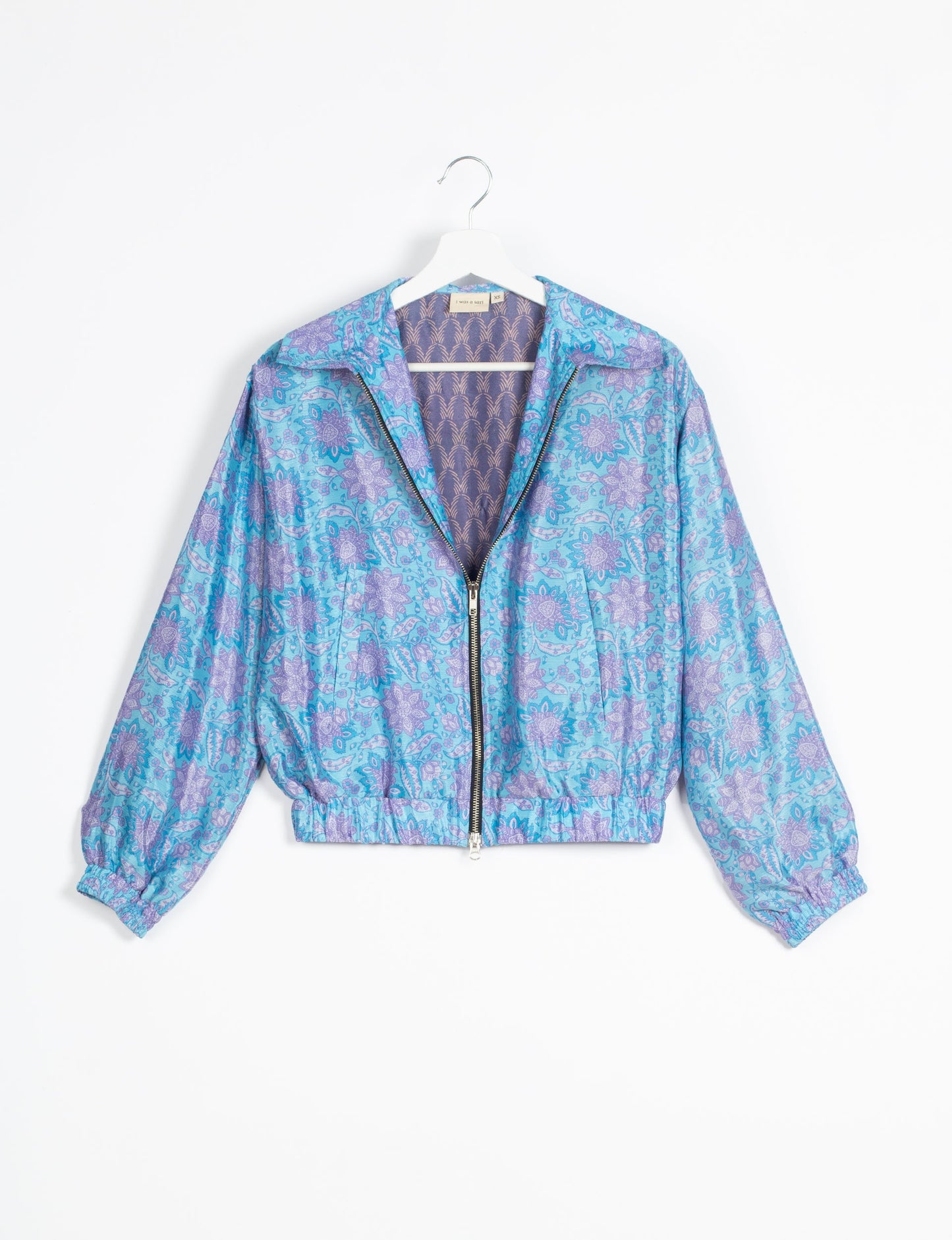 Stylish BOMBER JACKET, an upcycled clothing masterpiece with a cute cropped shape, elasticated details, and detachable metallic zipper. Contrast sari print lining adds a unique touch. Explore sustainable and eco-friendly fashion.