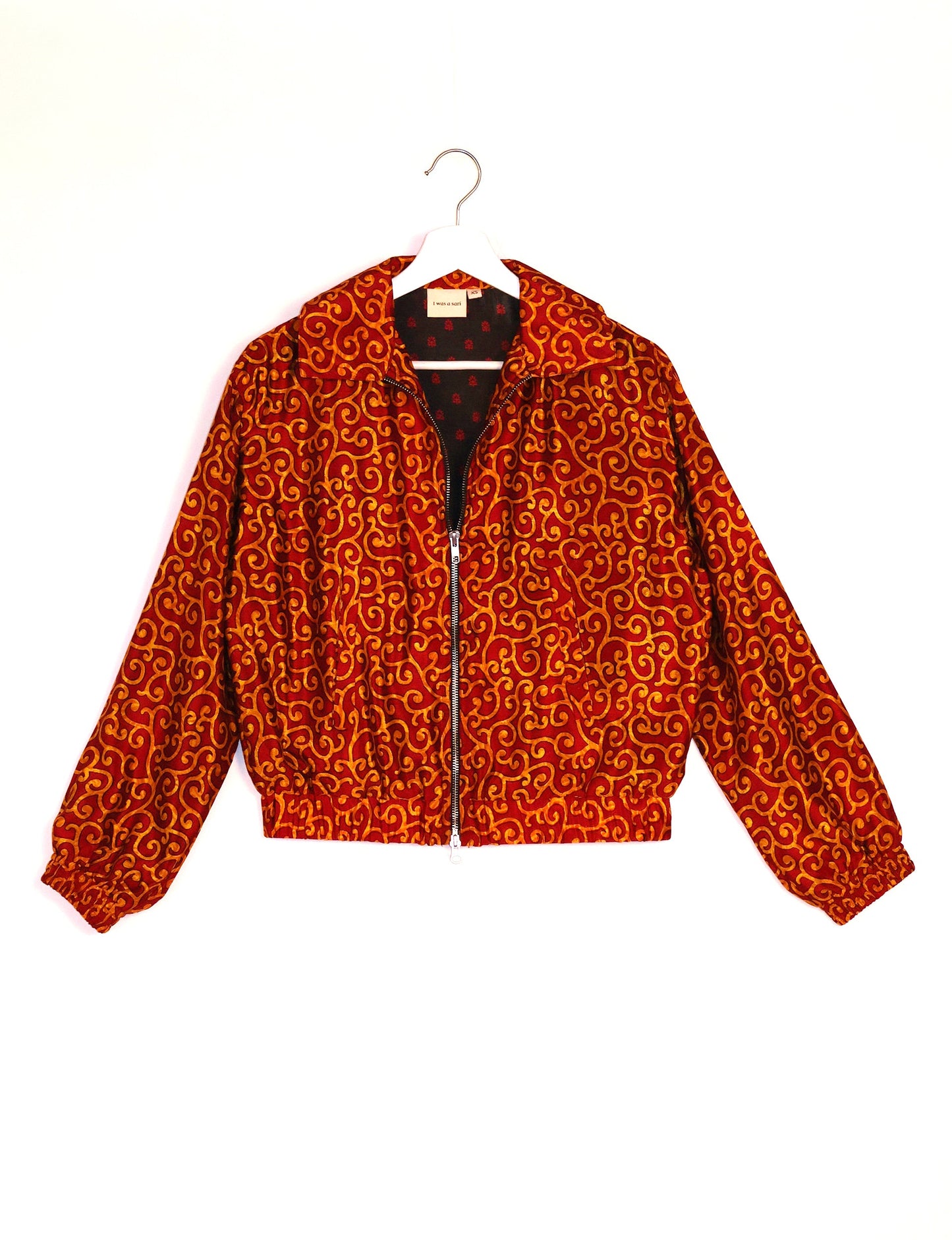 Stylish BOMBER JACKET, an upcycled clothing masterpiece with a cute cropped shape, elasticated details, and detachable metallic zipper. Contrast sari print lining adds a unique touch. Explore sustainable and eco-friendly fashion.