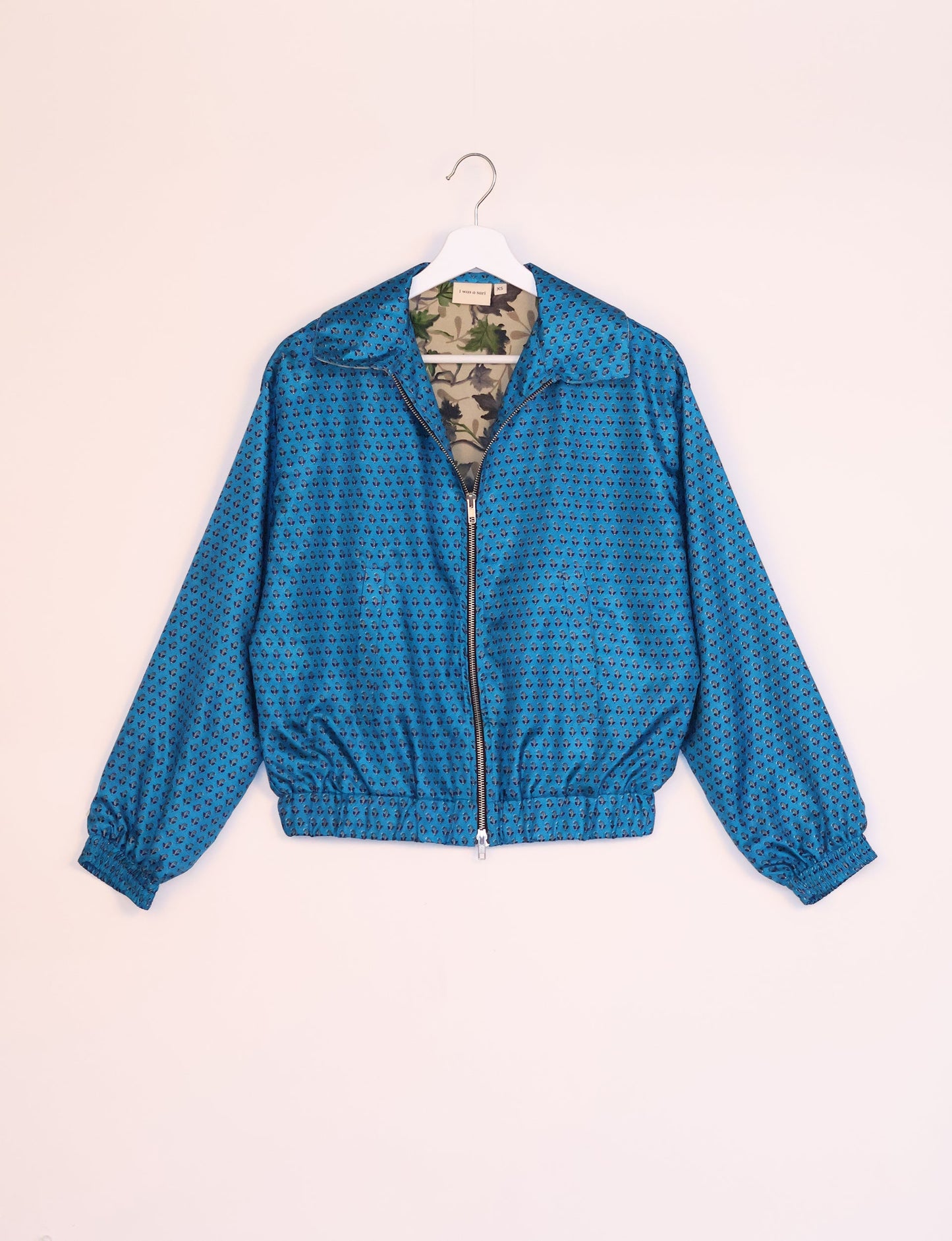 Stylish BOMBER JACKET, an upcycled clothing masterpiece with a cute cropped shape, elasticated details, and detachable metallic zipper. Contrast sari print lining adds a unique touch. Explore sustainable and eco-friendly fashion.