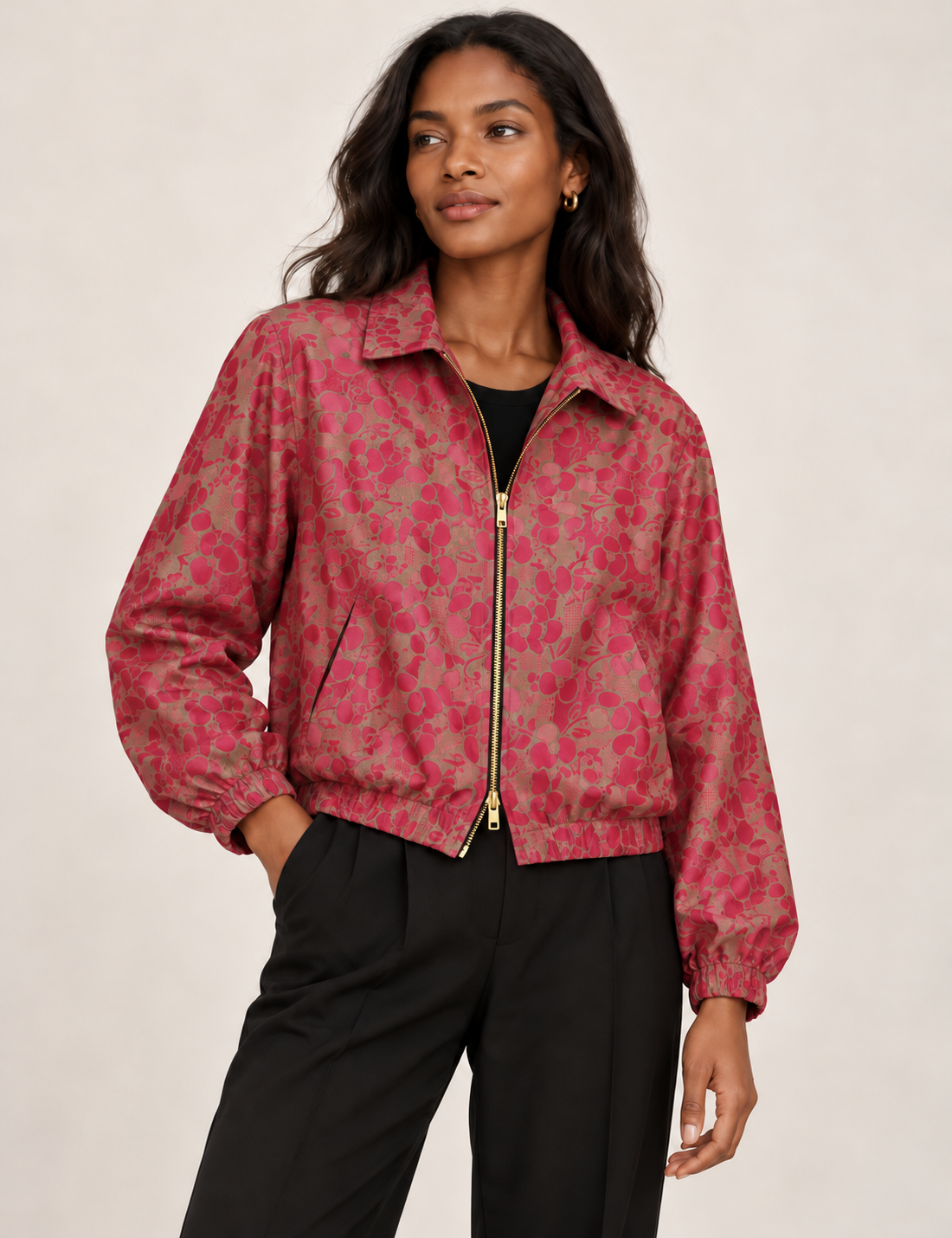 Woman wearing a yellow floral bomber jacket with front zipper, elastic cuffs, and side pockets, shown from front view
