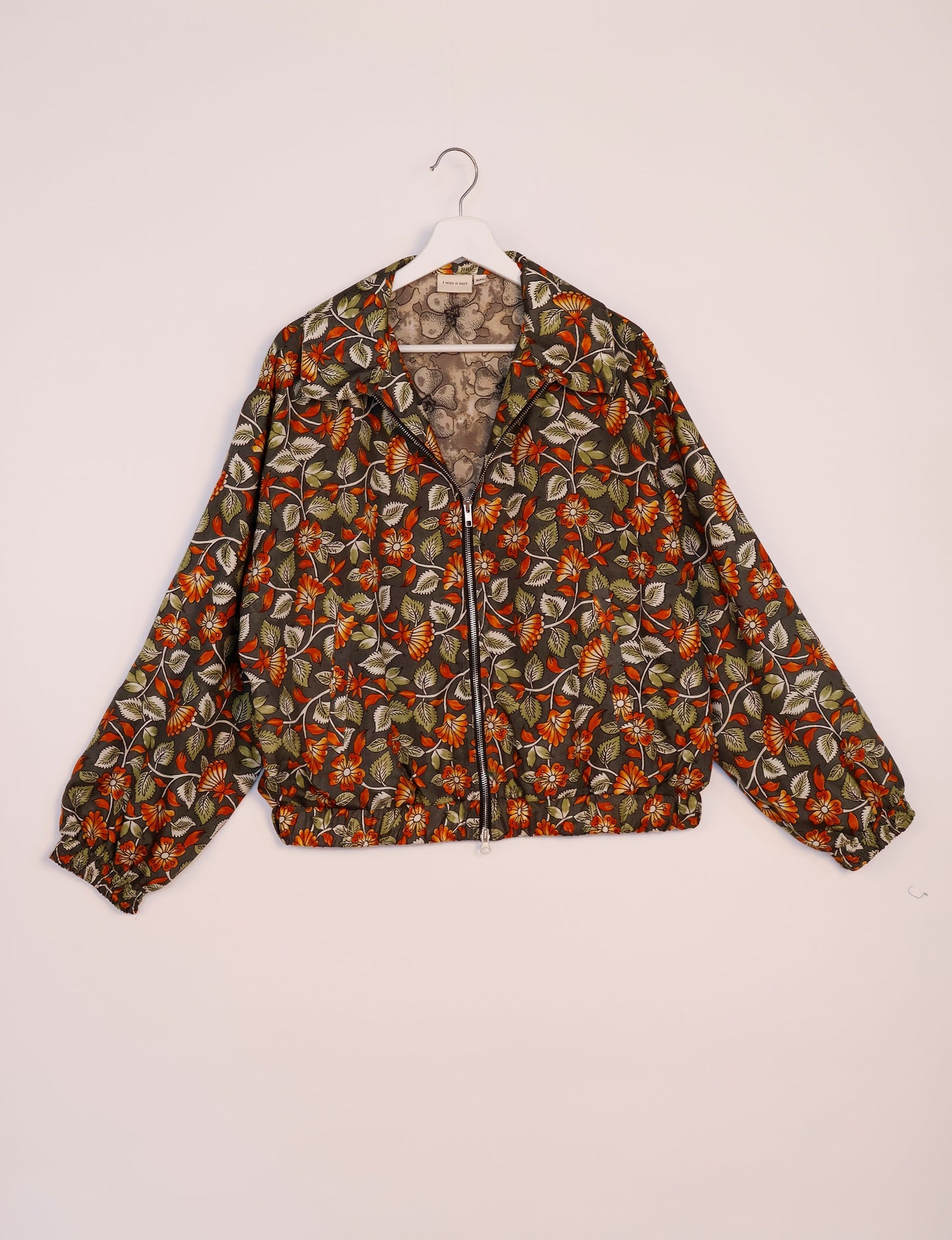 Stylish BOMBER JACKET, an upcycled clothing masterpiece with a cute cropped shape, elasticated details, and detachable metallic zipper. Contrast sari print lining adds a unique touch. Explore sustainable and eco-friendly fashion.