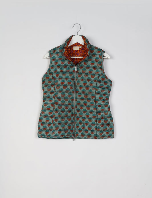 Elevate your style with our QUILTED GILET, crafted from upcycled tropical saris. This sleeveless jacket, with its quilted warmth, is perfect for layering over tees or sweaters. Choose ethical, green fashion and experience the comfort of sustainable living with a touch of home.