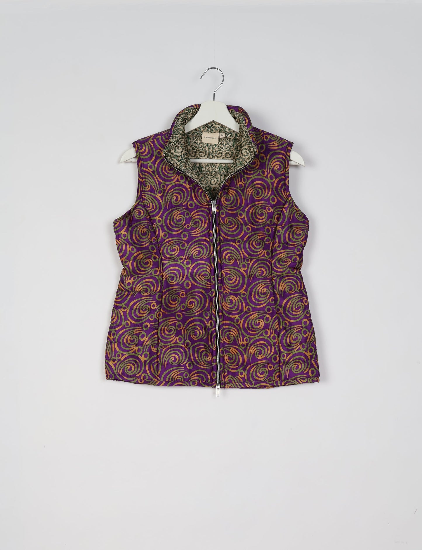 Elevate your style with our QUILTED GILET, crafted from upcycled tropical saris. This sleeveless jacket, with its quilted warmth, is perfect for layering over tees or sweaters. Choose ethical, green fashion and experience the comfort of sustainable living with a touch of home.