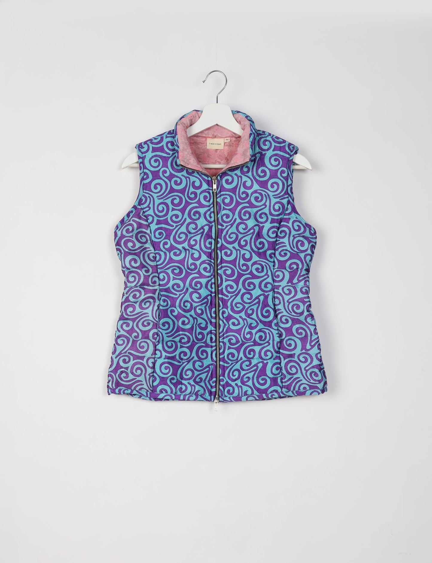 Elevate your style with our QUILTED GILET, crafted from upcycled tropical saris. This sleeveless jacket, with its quilted warmth, is perfect for layering over tees or sweaters. Choose ethical, green fashion and experience the comfort of sustainable living with a touch of home.