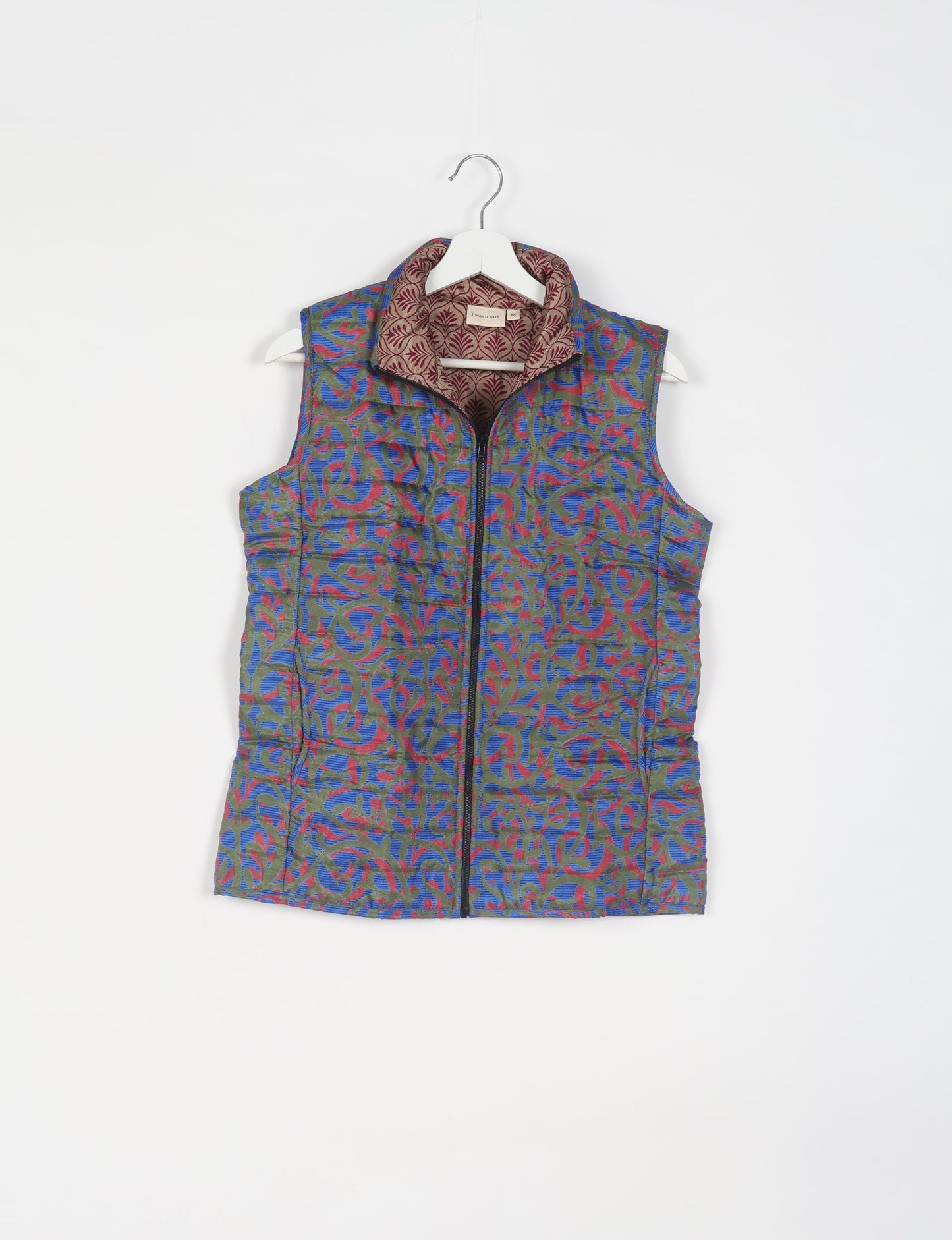 Elevate your style with our QUILTED GILET, crafted from upcycled tropical saris. This sleeveless jacket, with its quilted warmth, is perfect for layering over tees or sweaters. Choose ethical, green fashion and experience the comfort of sustainable living with a touch of home.