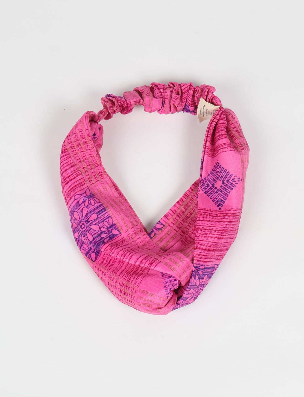 Pink floral patterned light turban with elastic back, shown flat on a white background