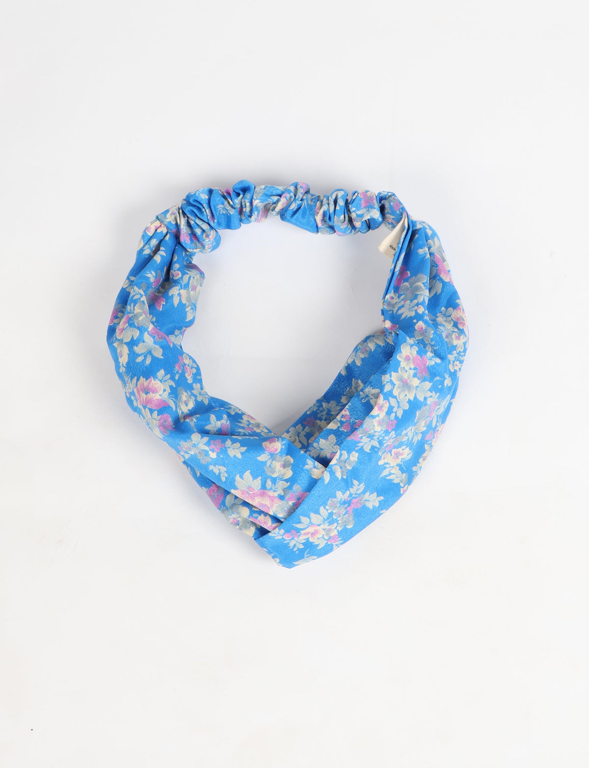 Blue turban with pink and white floral pattern, gathered elastic band, flat lay on white background