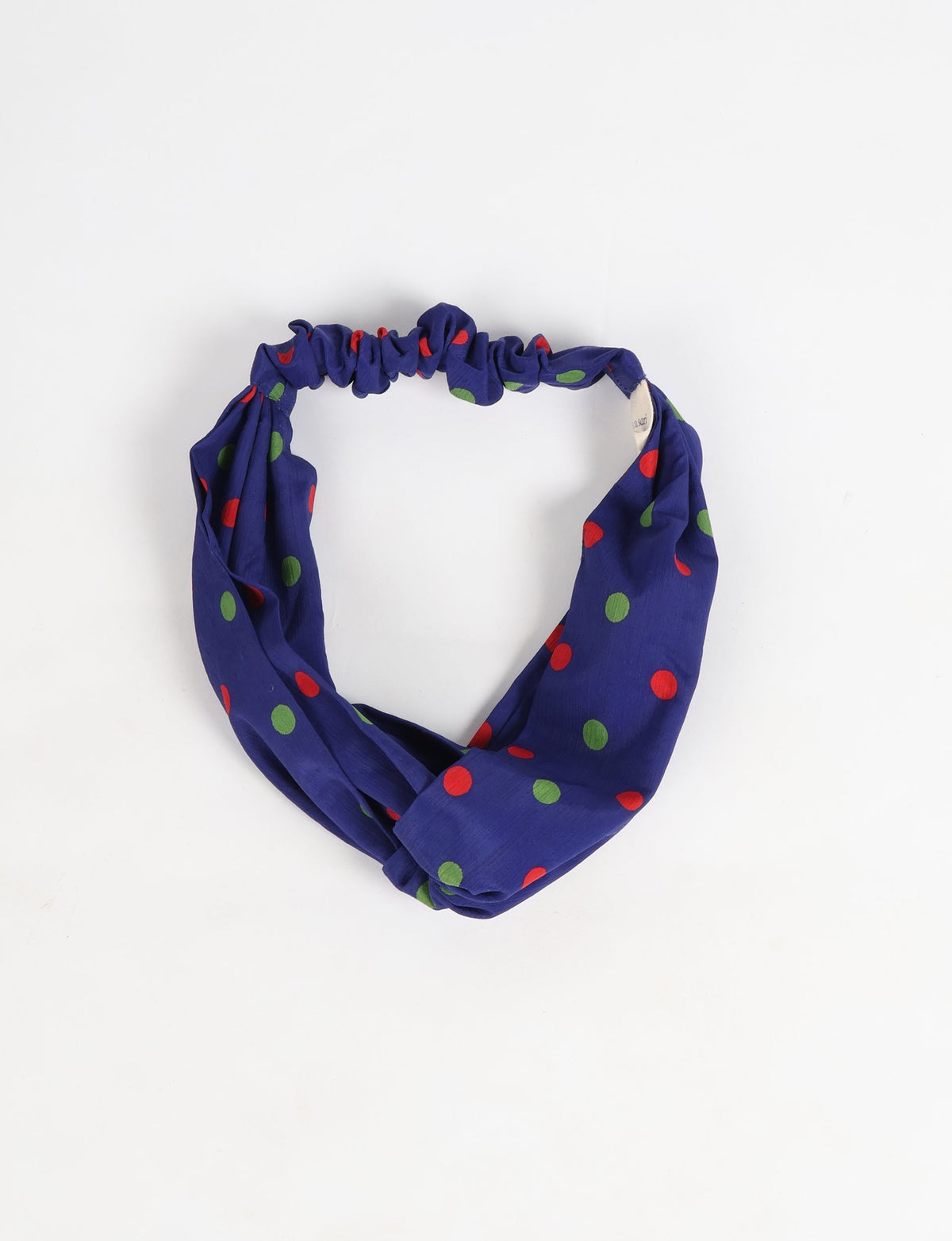 Blue turban headband with red and green polka dots, gathered elastic back, flat lay on white background