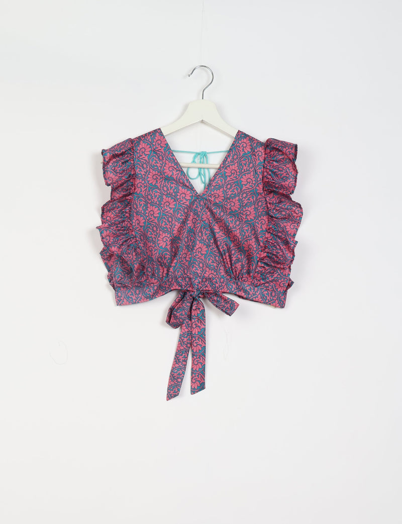 Pink and blue floral patterned frill sleeve crop top with V-neck and tie waist, hanging on white hanger against white background
