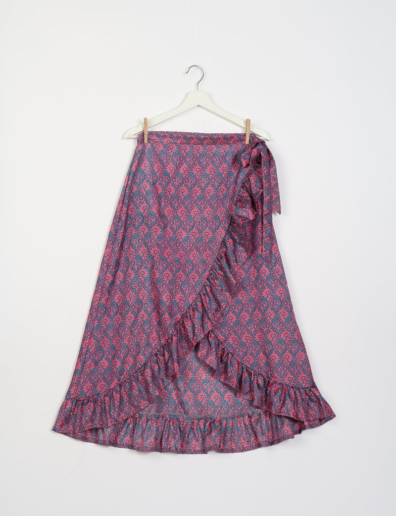 Pink and blue floral patterned frill skirt with ruffle trim hanging on white hanger against white background