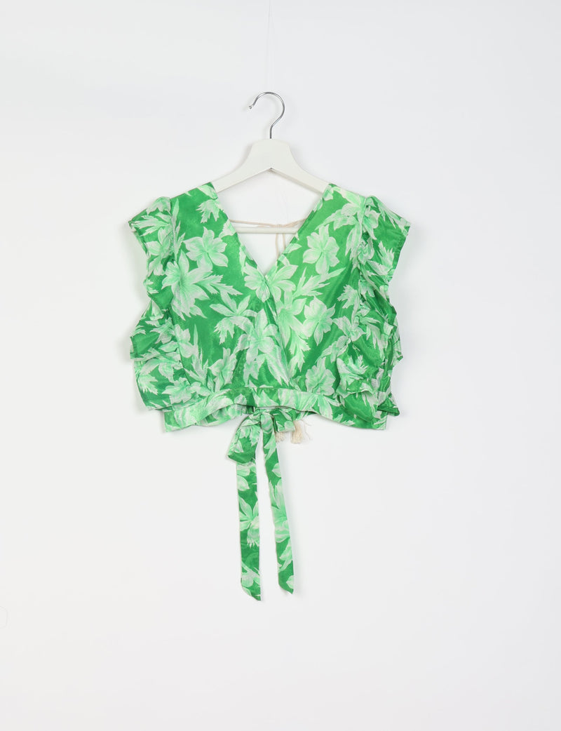 Green cropped wrap top with light green leaf print, ruffled sleeves, and tie belt, hanging on white hanger front view
