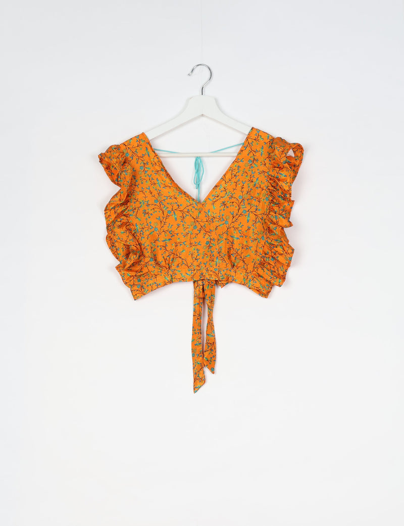 Orange floral crop top with ruffled sleeves, V-neckline, and back tie detail hanging on white hanger