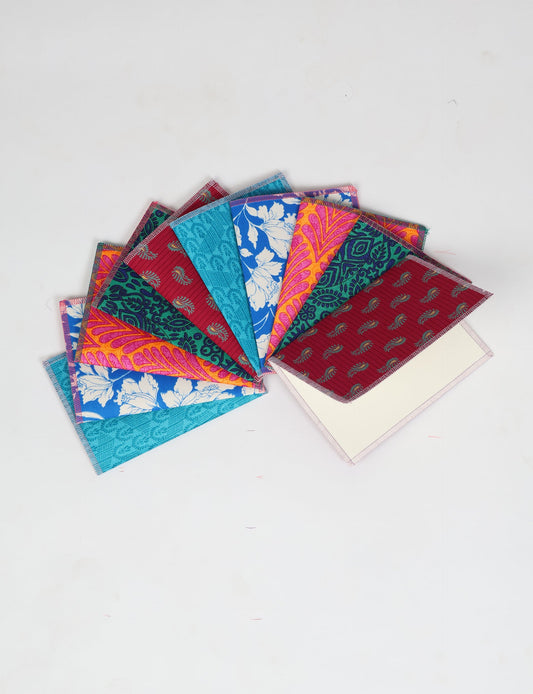 Sustainably crafted FOLDED POSTCARD SET, 10 assorted pieces made with 100% recycled paper and printed sari fabric sourced from Mumbai markets. Eco-friendly with contrast overlock edging. Envelopes included for eco-conscious gratitude and cheerful messages to loved ones.