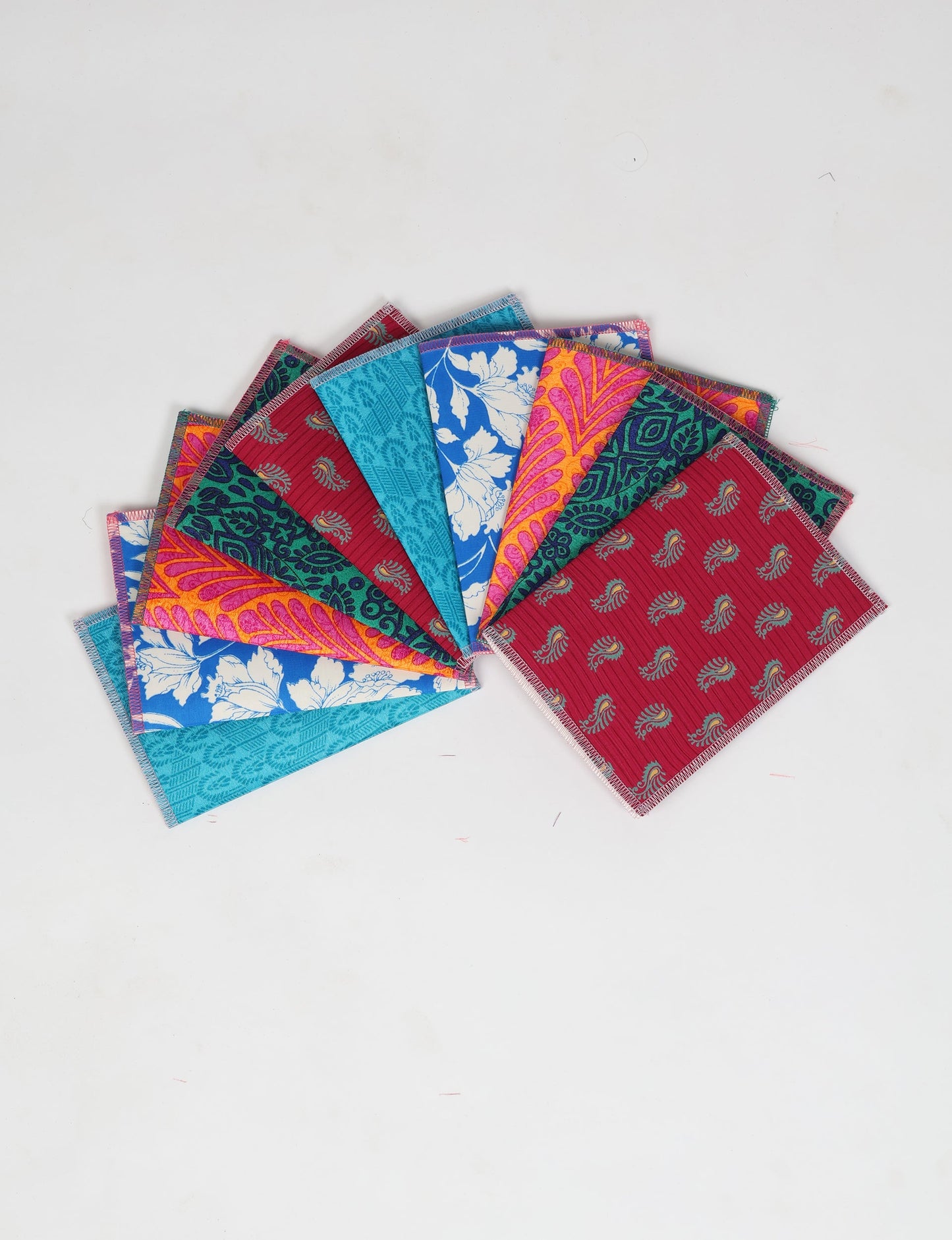 Sustainably crafted FOLDED POSTCARD SET, 10 assorted pieces made with 100% recycled paper and printed sari fabric sourced from Mumbai markets. Eco-friendly with contrast overlock edging. Envelopes included for eco-conscious gratitude and cheerful messages to loved ones.