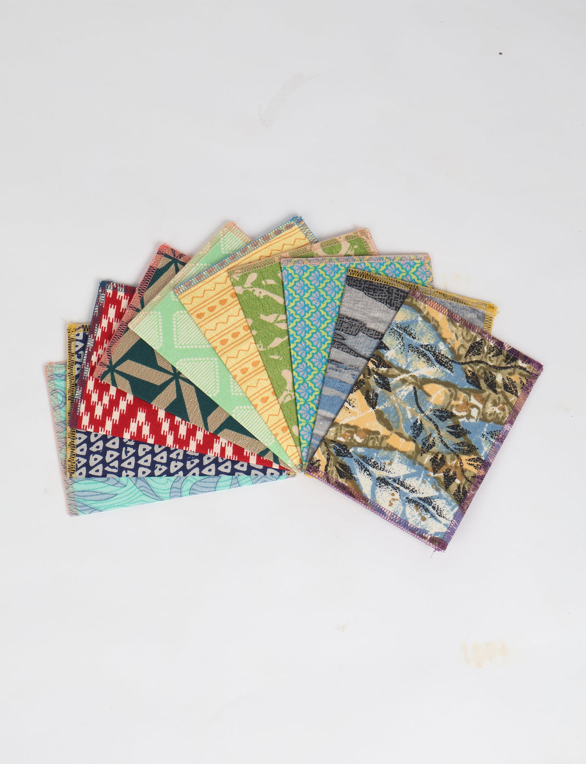 Set of 10 folded postcards with colorful geometric, floral, and abstract patterns, shown fanned out on white background