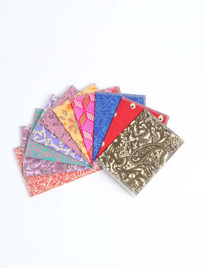 Folded postcards set with colorful upcycled sari fabric covers, showing various patterns and colors, fanned out on white background