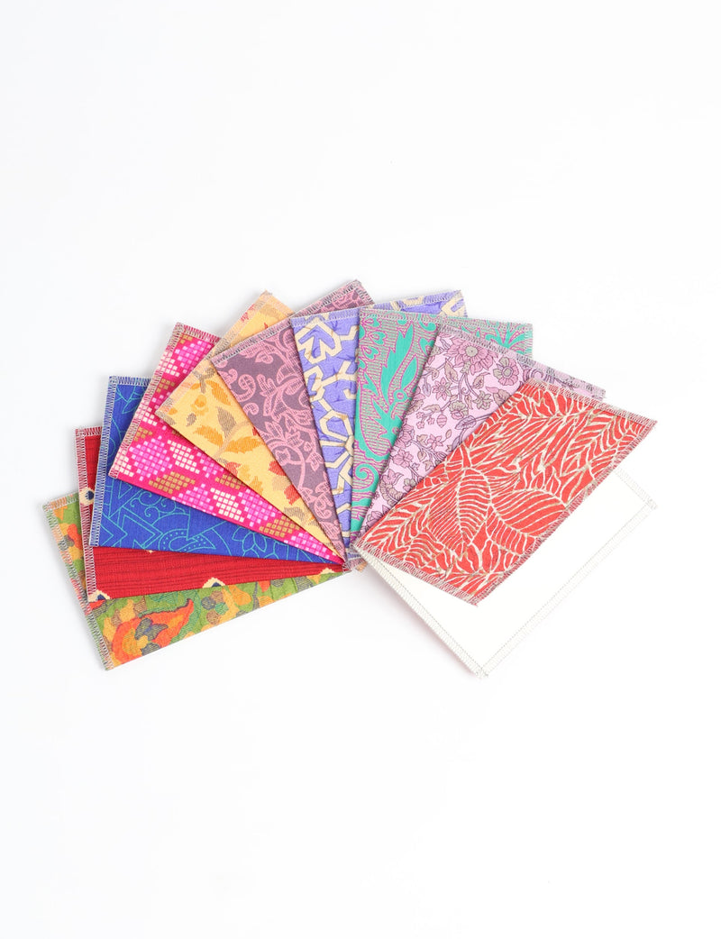 Set of 10 folded postcards with colorful, patterned fabric covers in various floral and geometric designs, fanned out on