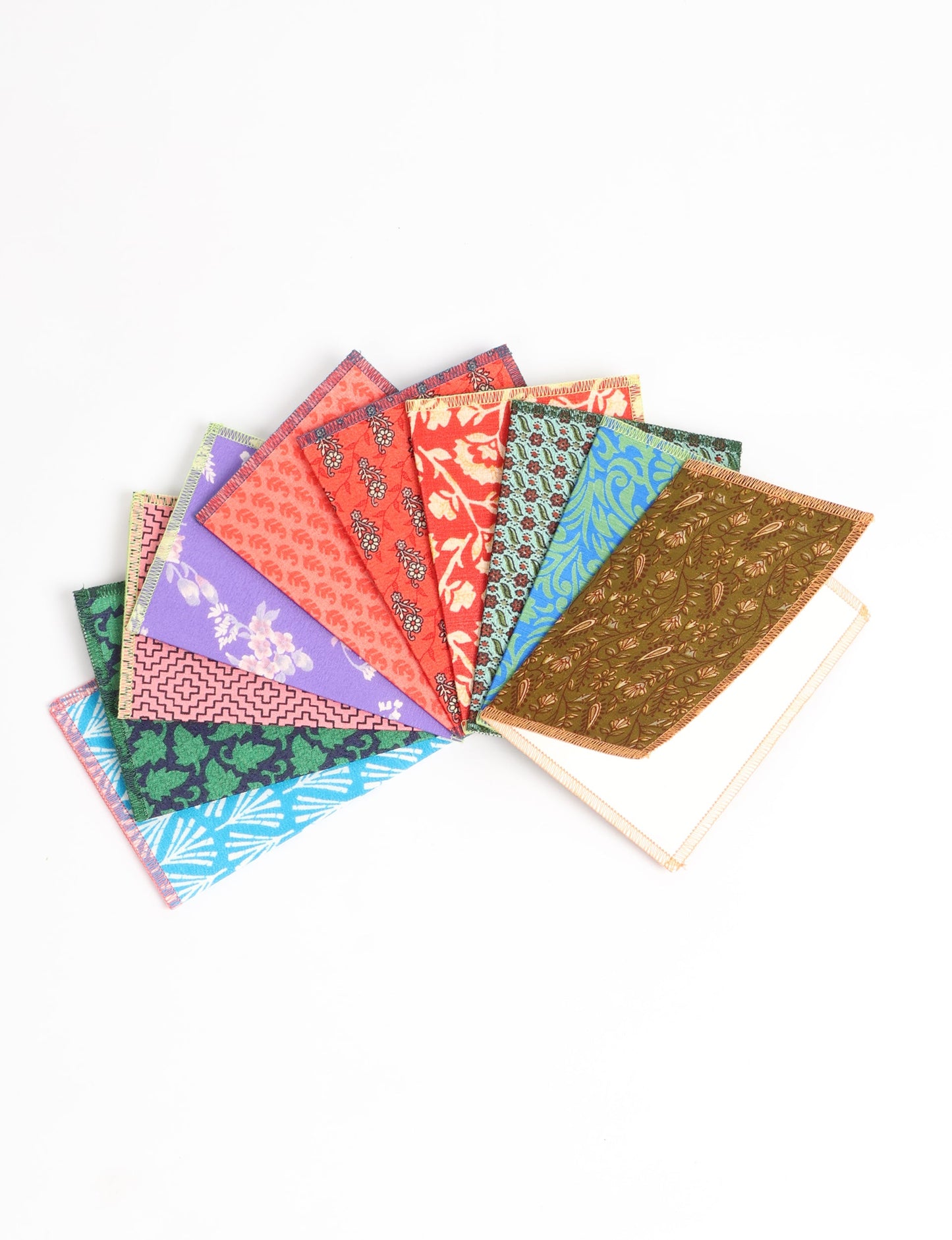 Sustainably crafted FOLDED POSTCARD SET, 10 assorted pieces made with 100% recycled paper and printed sari fabric sourced from Mumbai markets. Eco-friendly with contrast overlock edging. Envelopes included for eco-conscious gratitude and cheerful messages to loved ones.
