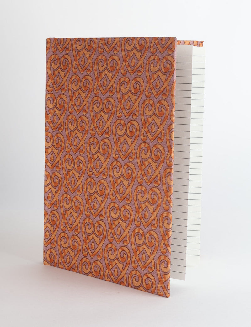 A5 hard cover notebook with orange and purple heritage pattern fabric cover, shown standing open with lined pages visible