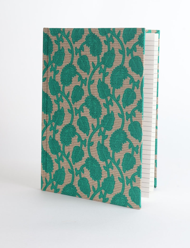 A5 hard cover notebook with green leaf and paisley pattern on beige textured fabric, shown standing open with lined pages visible