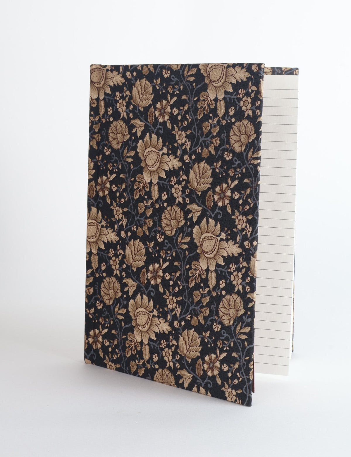 A5 hard cover notebook with dark blue cover featuring beige floral pattern, shown partially open with lined pages visible
