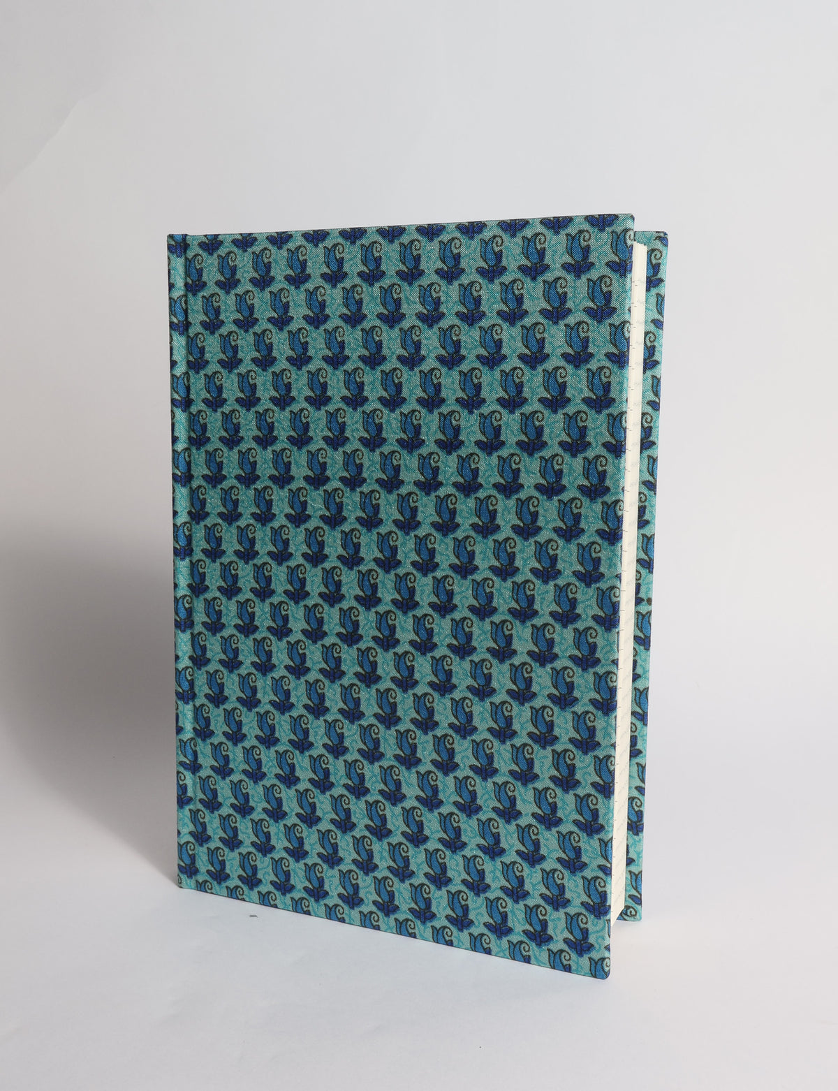 A5 hard cover notebook with dark blue cover featuring beige floral pattern, shown partially open with lined pages visible