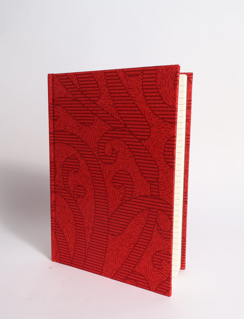 A5 hard cover notebook with dark blue cover featuring beige floral pattern, shown partially open with lined pages visible