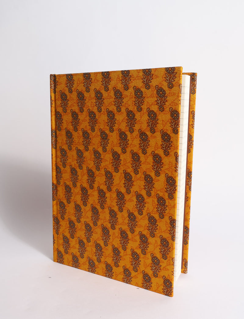 A5 hard cover notebook with dark blue cover featuring beige floral pattern, shown partially open with lined pages visible