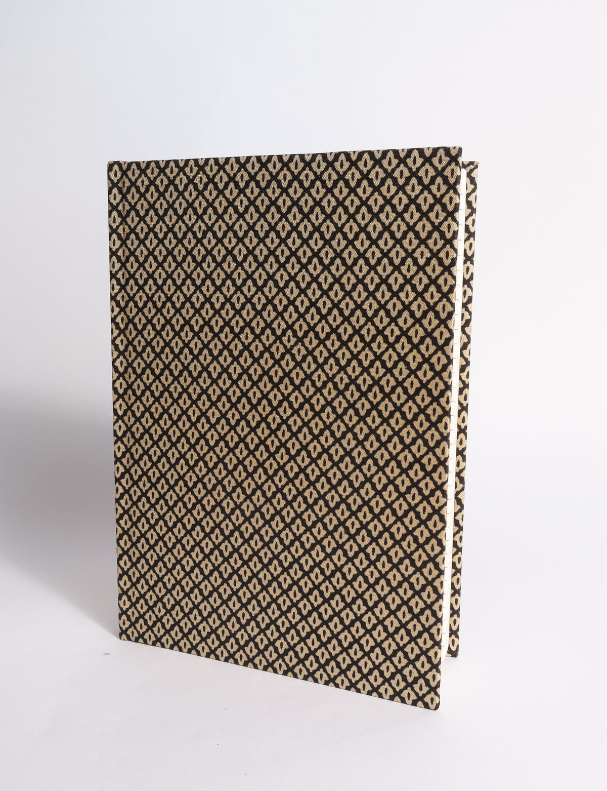 A5 hard cover notebook with dark blue cover featuring beige floral pattern, shown partially open with lined pages visible