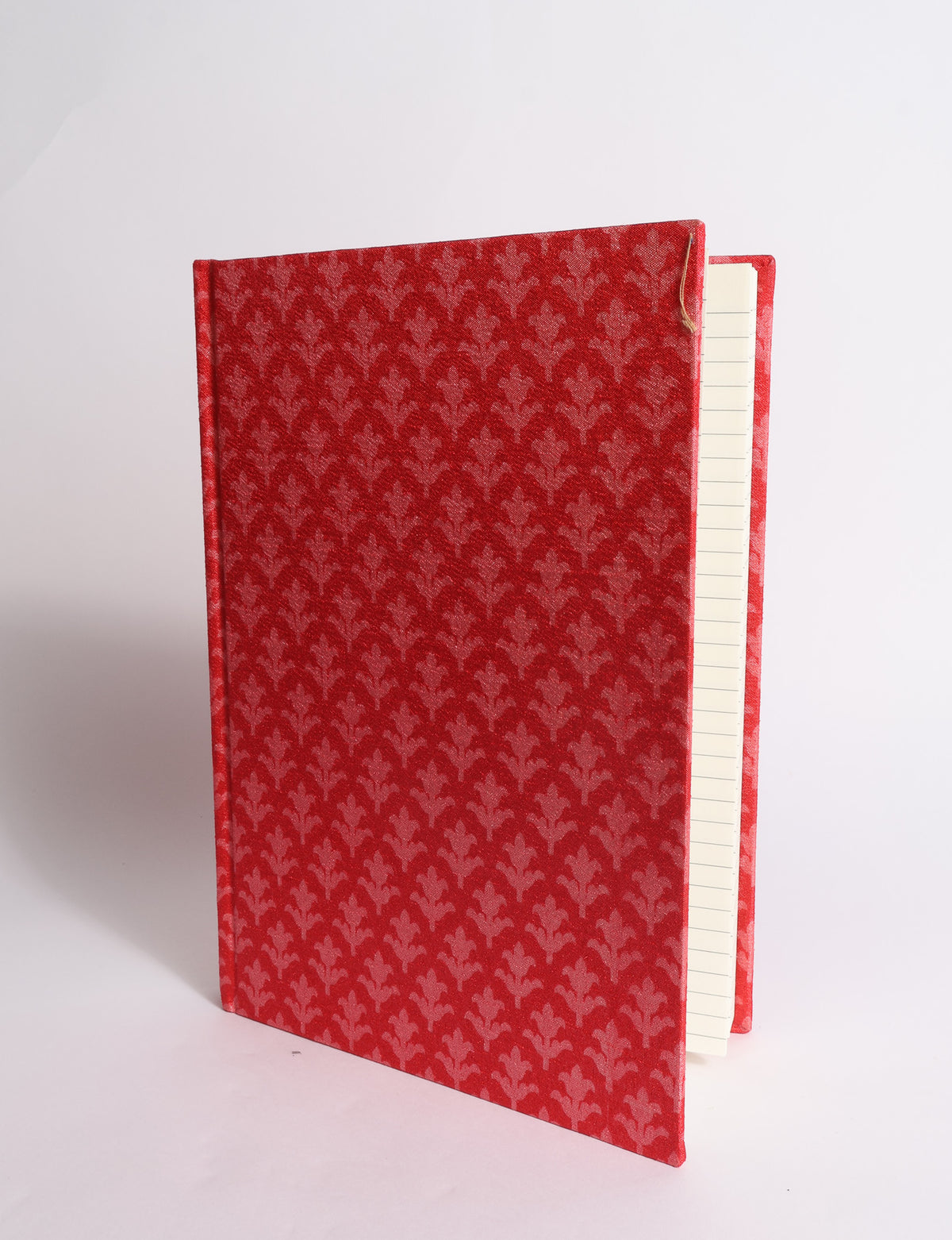 A5 hard cover notebook with dark blue cover featuring beige floral pattern, shown partially open with lined pages visible