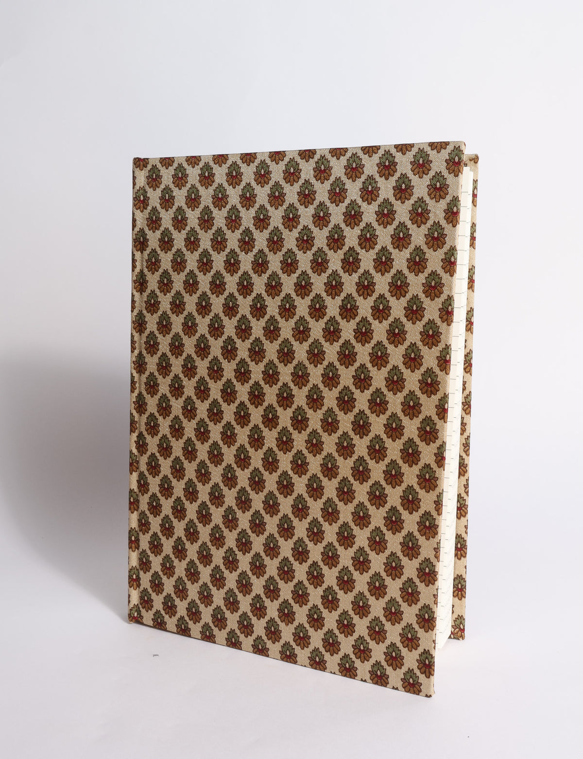 A5 hard cover notebook with dark blue cover featuring beige floral pattern, shown partially open with lined pages visible