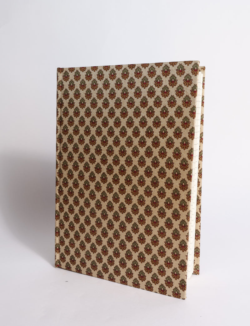 A5 hard cover notebook with dark blue cover featuring beige floral pattern, shown partially open with lined pages visible