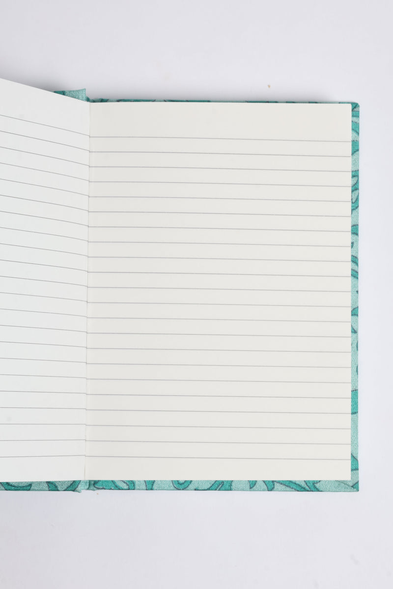 Open A6 hard cover notebook with turquoise pre-loved sari fabric cover and square-lined white pages visible