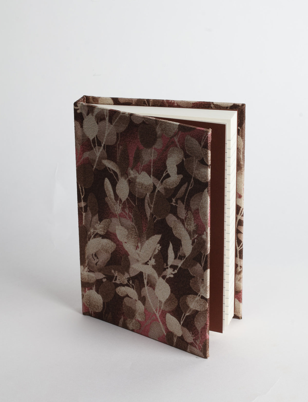 A6 hard cover notebook with teal pre-loved sari fabric cover featuring dark green floral vine pattern, standing upright
