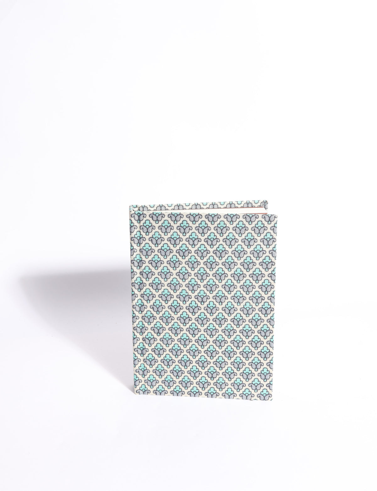 A6 hard cover notebook with teal pre-loved sari fabric cover featuring dark green floral vine pattern, standing upright