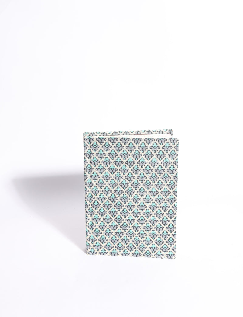 A6 hard cover notebook with teal pre-loved sari fabric cover featuring dark green floral vine pattern, standing upright