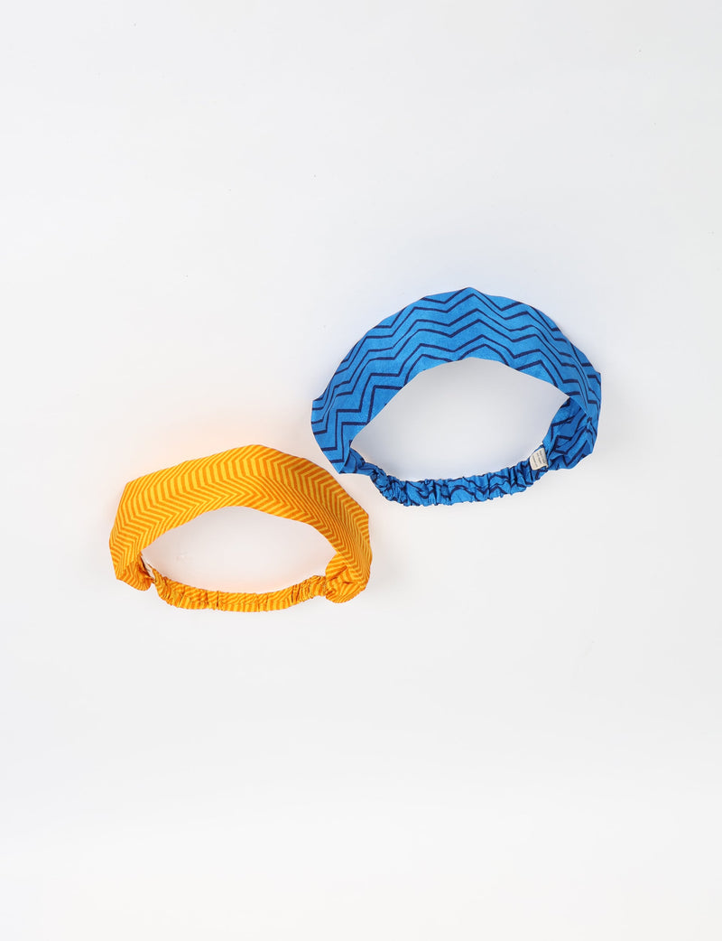 Set of two elastic headbands in blue and orange with zigzag patterns, shown flat on a white background