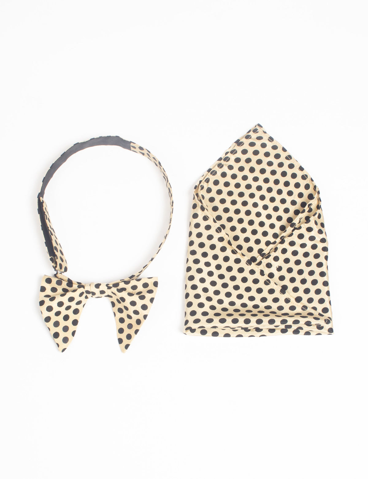 Beige bow tie and pocket square set with black polka dots, flat lay on white background