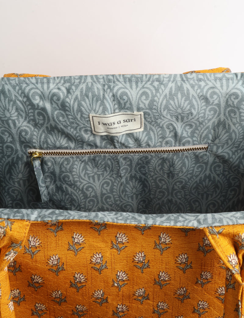 Grey floral fabric work tote bag with blue and beige flowers, teal interior lining with beige polka dots, and fabric handles