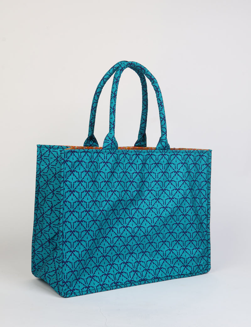 Blue tropical patterned fabric work tote bag with double handles, shown in a side angle view on a white background