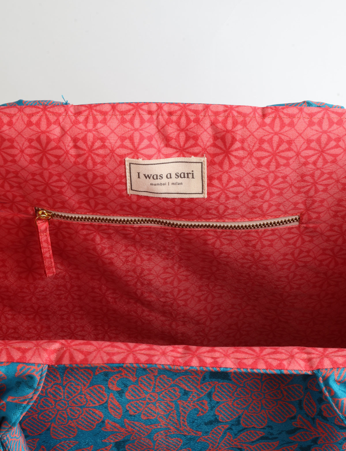 Grey floral fabric work tote bag with blue and beige flowers, teal interior lining with beige polka dots, and fabric handles