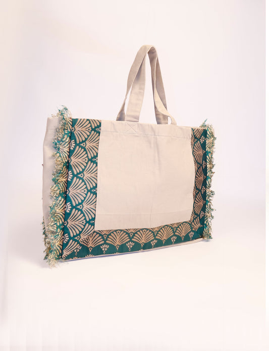 Lighten your eco-load with our FRINGE CARRY-ALL BAG. Soft canvas with a patchwork design, inside lining made of vibrant sari fabric, and beautifully soft sari-fringed edging. Crafted with 100% cotton canvas for a sustainable and stylish carry-all.