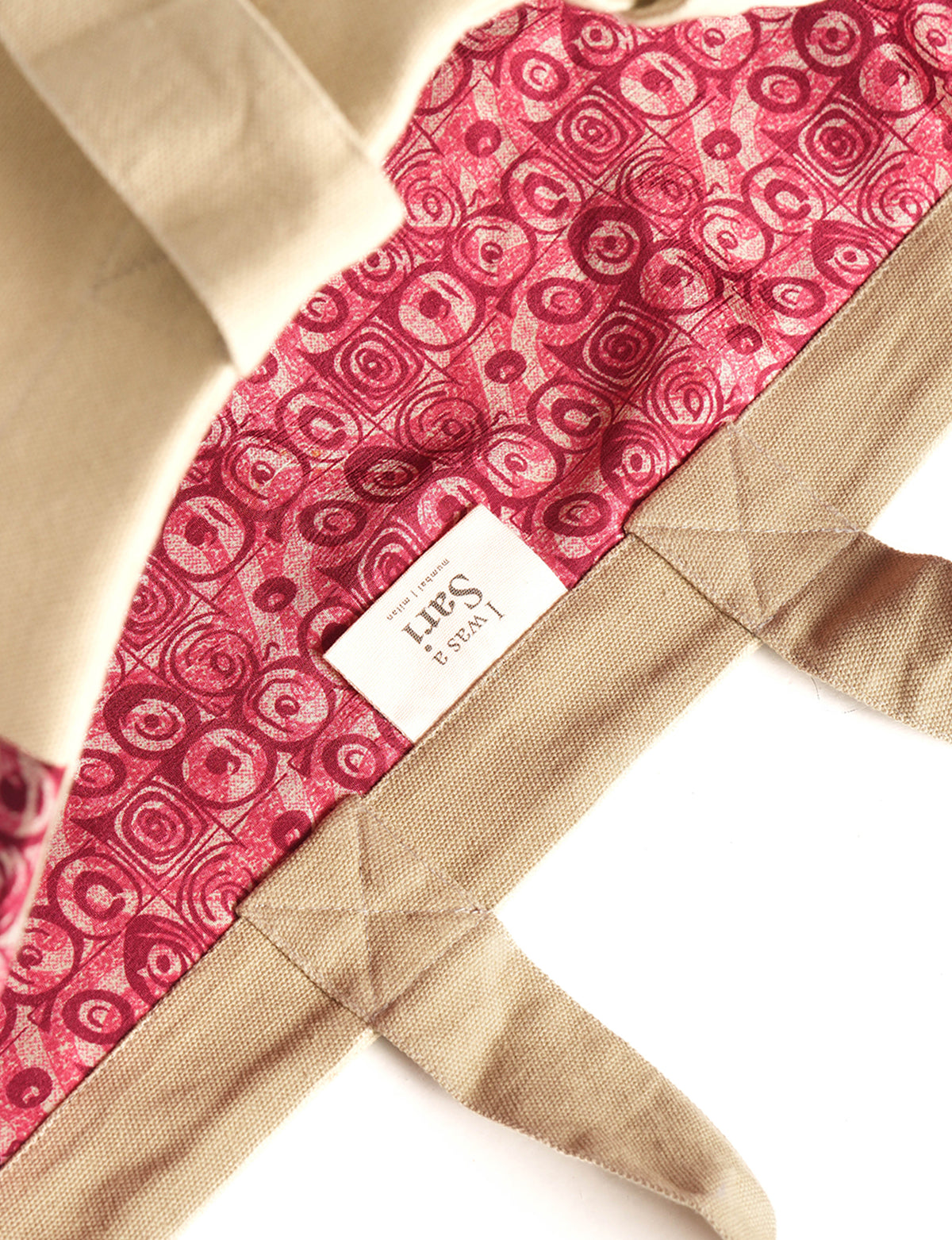 Beige fabric carry-all bag with pink abstract circular pattern lining and sewn-in label inside the bag interior