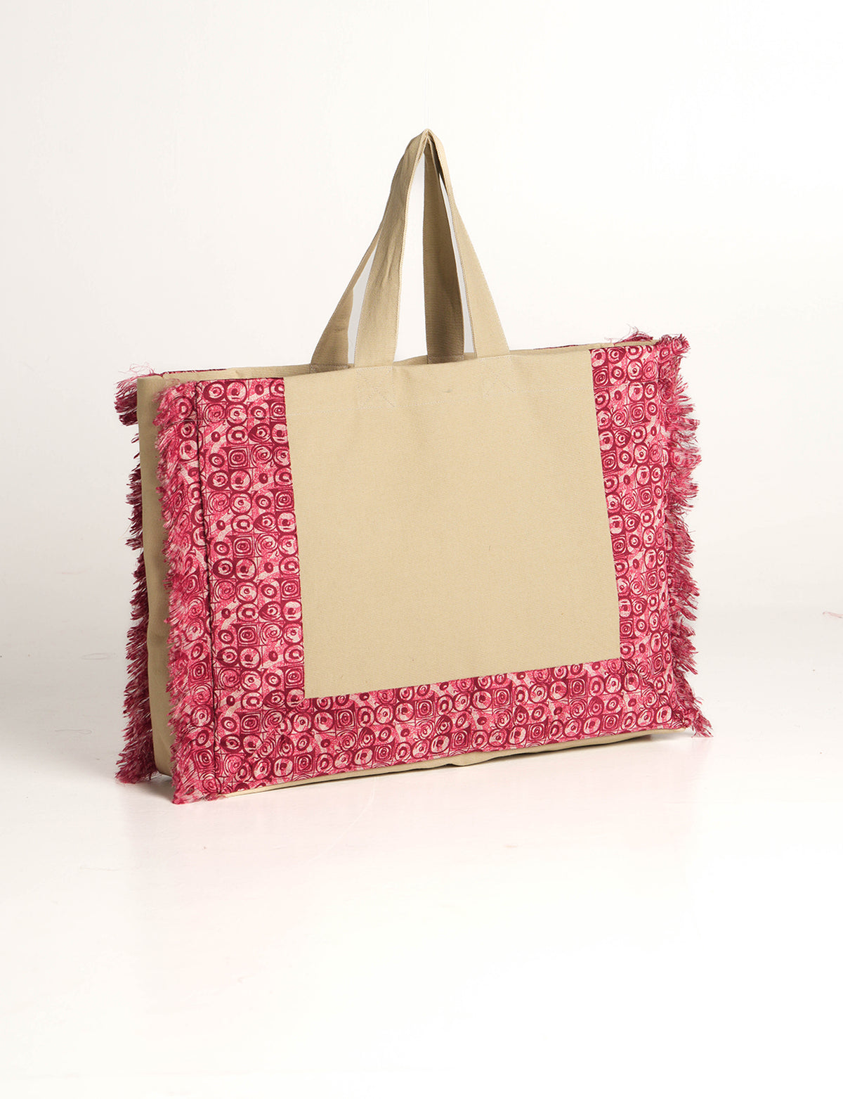 Beige canvas carry-all bag with pink abstract patterned fringe trim and double handles, shown front side view