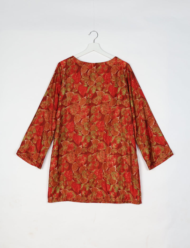 Red swing dress with long sleeves and all-over red and green leaf pattern, shown hanging on white hanger, back view