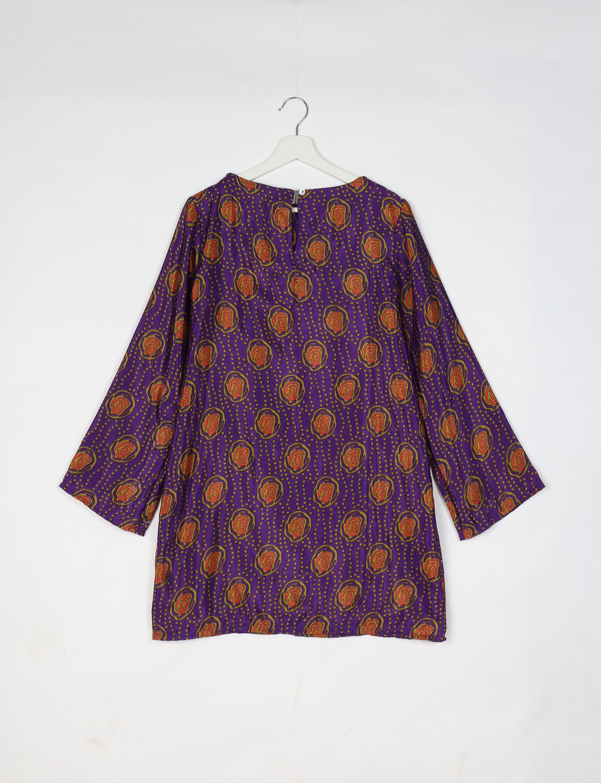 Purple swing dress with red and yellow floral pattern, long sleeves, and back button closure, hanging on white hanger
