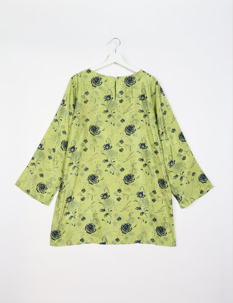Green swing dress with black floral print, long sleeves, and a back button closure, shown hanging on a white hanger