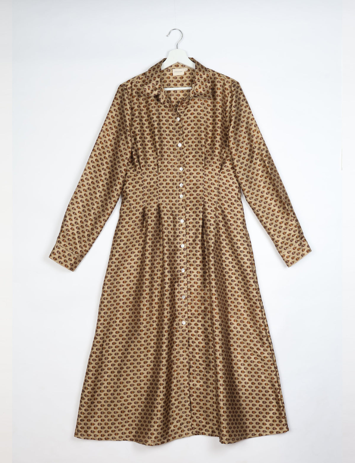 Beige midi shirt dress with brown micro paisley pattern, long sleeves, button front, and pointed collar hanging on white hanger